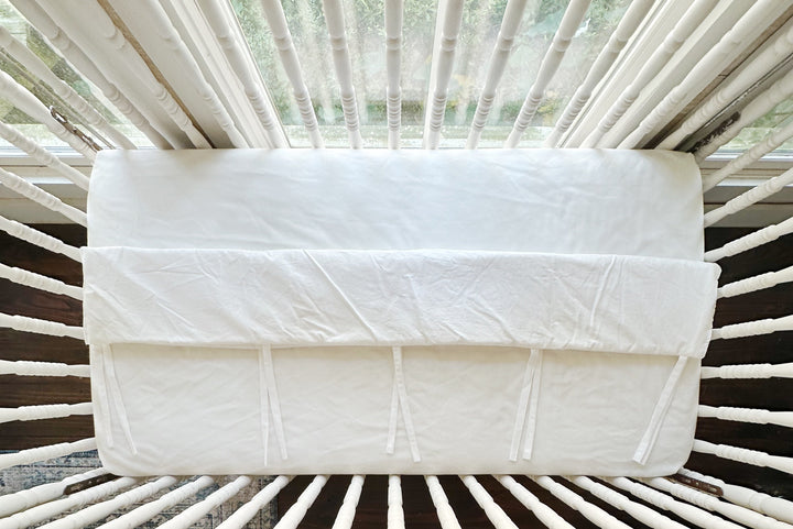 Close view of the tailored edge of the white cover where it folds over the top rail