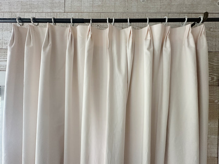 Straight-on view across a pleated Ballet Slipper Pink panel hanging from white rings
