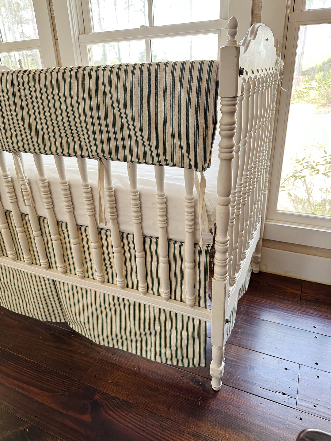 The corner of the rail cover where it folds over the top rail, natural ties hanging loose between the spindles
