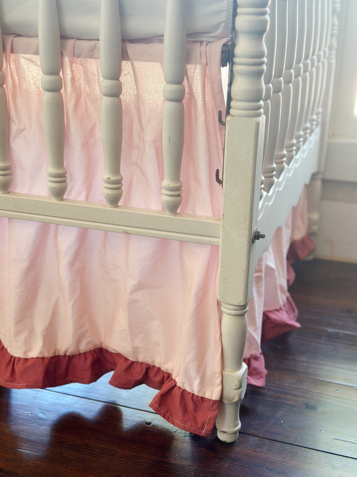 Sunlit crib corner, Sisters Pink skirt falling past the turned leg with its blush ruffle grazing the floor