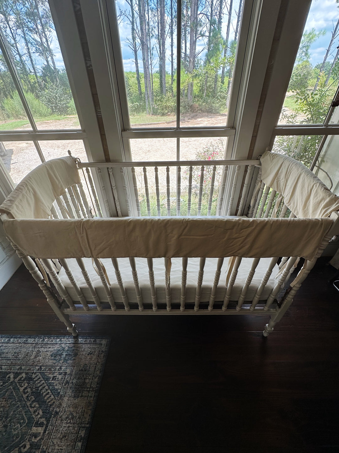 Full crib set of Natural crib rail covers on the long and short top rails of a white wooden crib