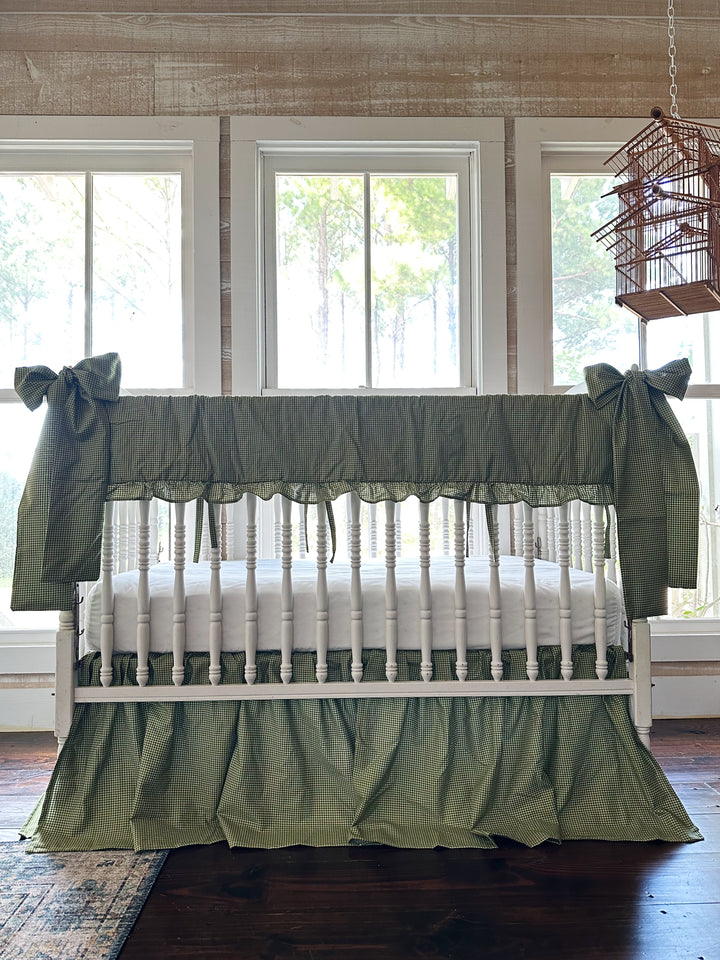 Green gingham crib bedding set styled on a white crib in a farmhouse nursery with pine views