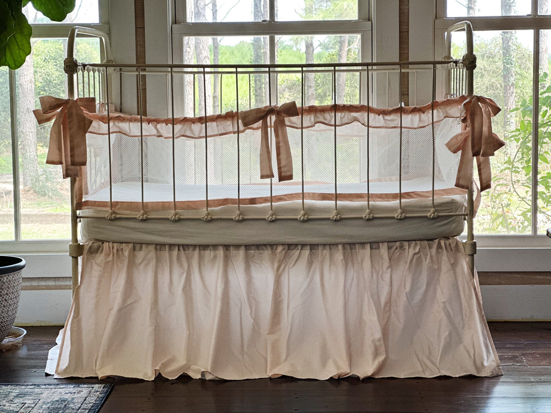 Detail of ruffle on mesh crib liner, emphasizing texture and delicate finishing