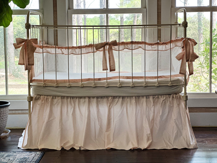 Detail of ruffle on mesh crib liner, emphasizing texture and delicate finishing