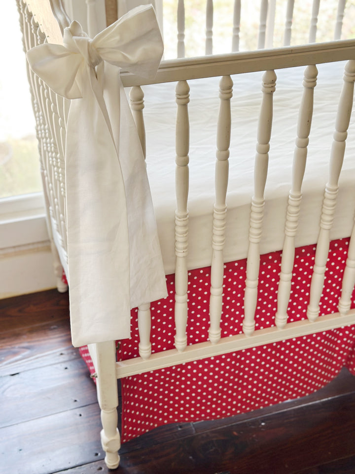 Close view of the washed cotton sash against the turned spindles and the small white dots on cherry red