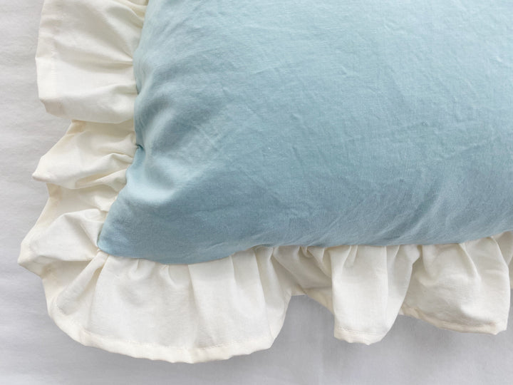 Close-up of the corner where the mist pillow body meets the gathered ivory cotton ruffle