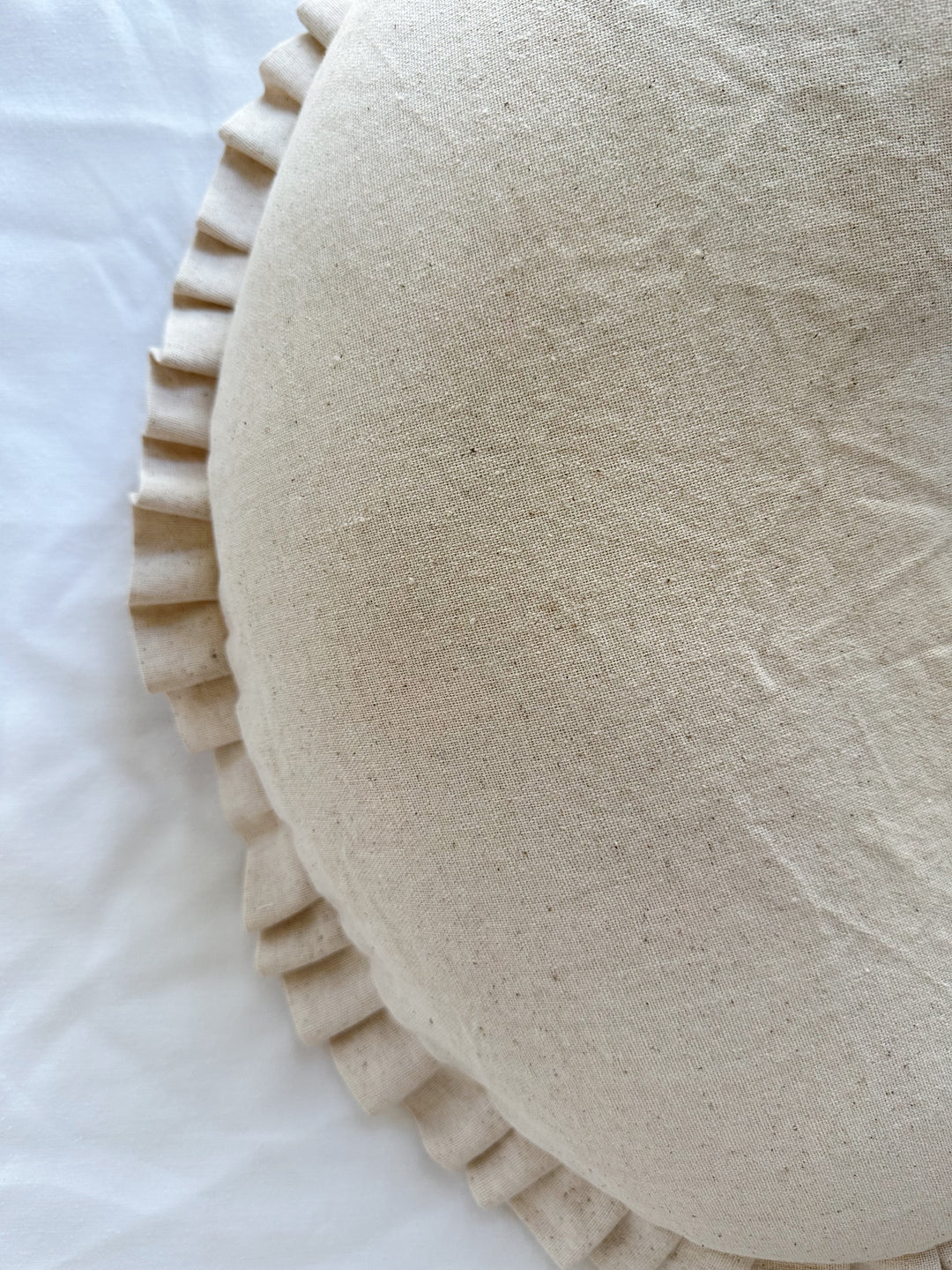 Flecked, slubby weave of the natural osnaburg cotton beside the pressed pleats of the ruffle