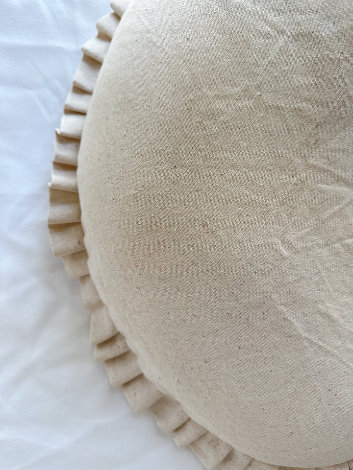 Flecked, slubby weave of the natural osnaburg cotton beside the pressed pleats of the ruffle