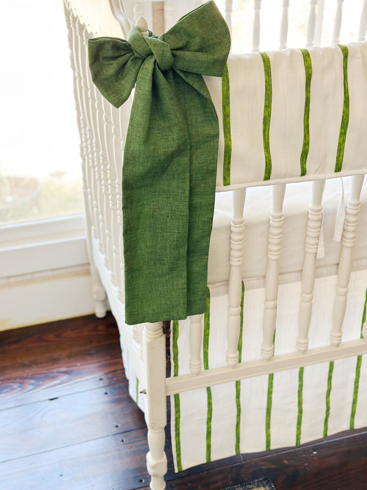Cypress green sash knotted at the corner post, its long tails falling past the striped skirt