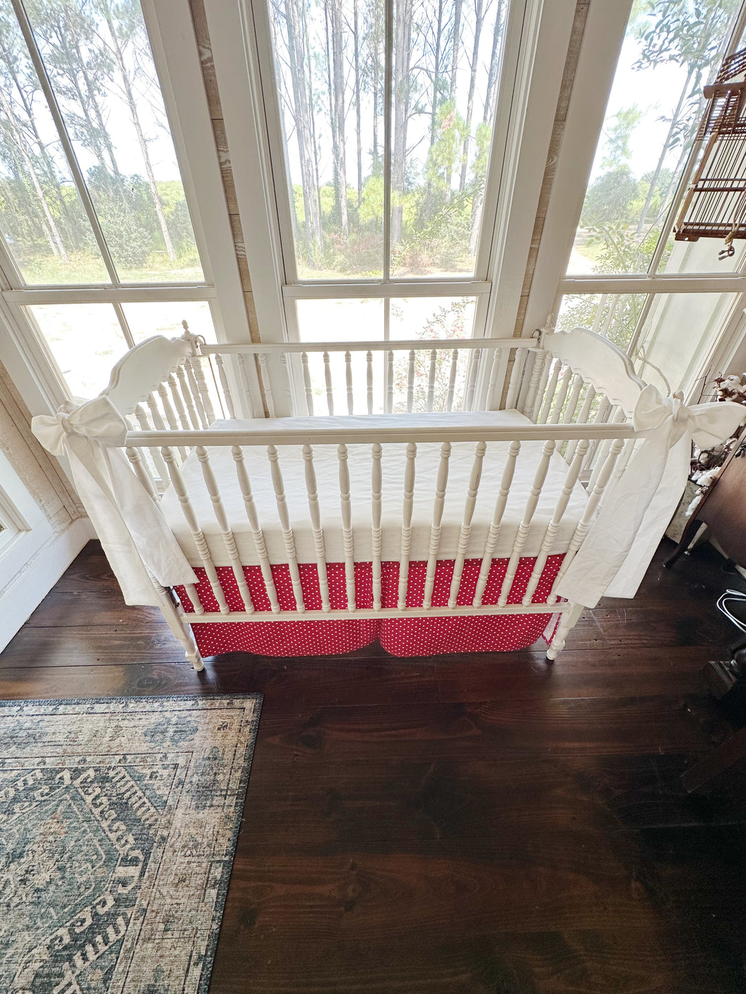 Overhead view of the crib showing both white sashes and the full length of the polka dot skirt