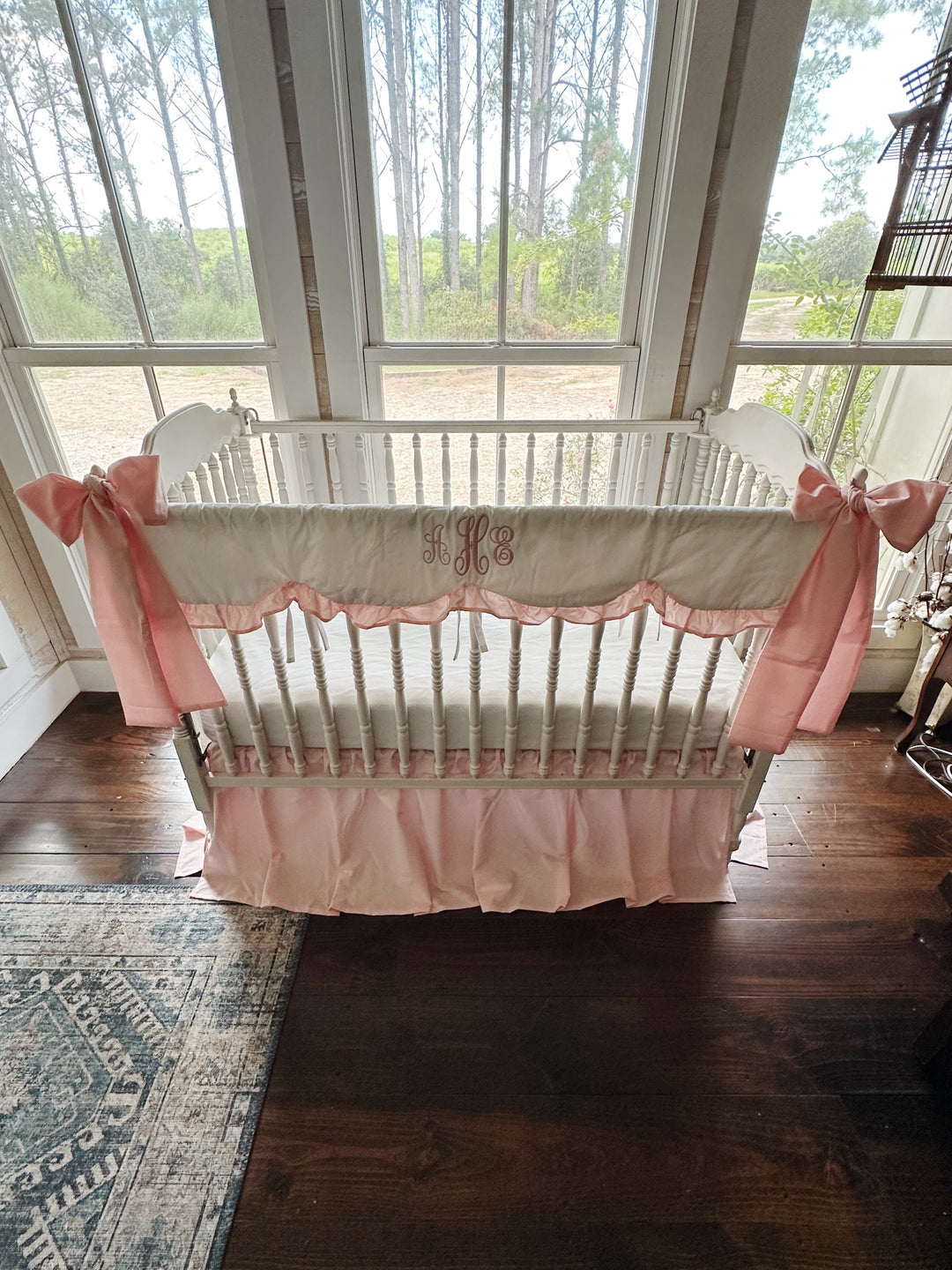 Sisters Pink scalloped crib rail cover and farmhouse crib skirt set shown with two large crib bows