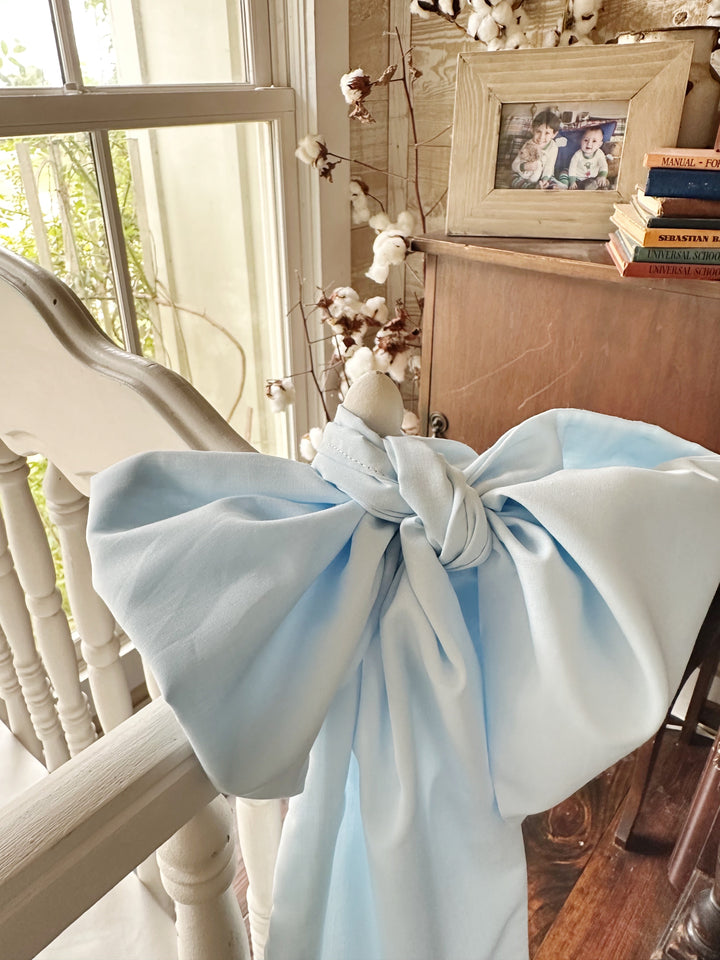 Close view of the heirloom blue bow with cotton stems and a framed photo behind it