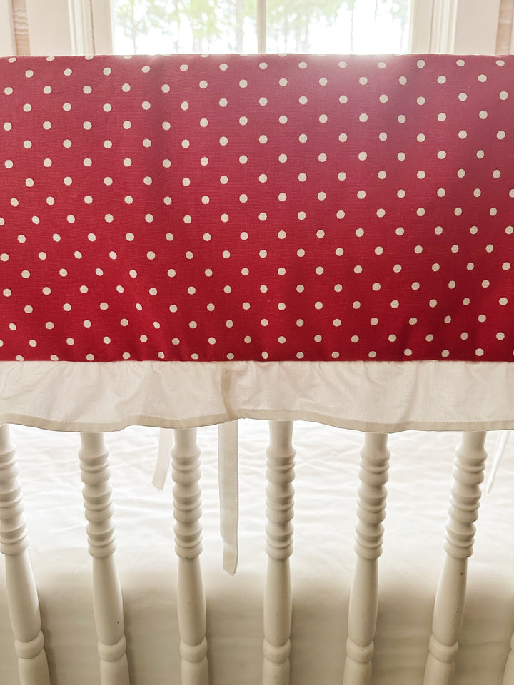 Close view of the small white dots on deep cherry red cotton above the gathered white ruffle