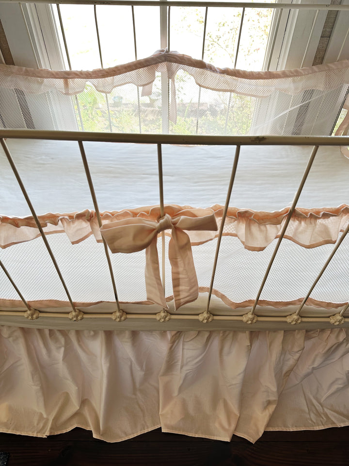 Farmhouse crib bedding set styled with additional nursery decor, soft pastel palette, crib liners and skirt visible