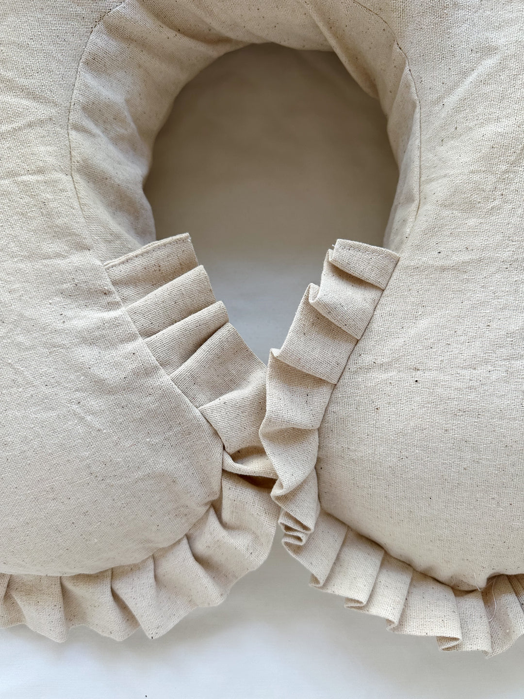 Pleated osnaburg ruffle wrapping both tips of the Natural Osnaburg Boppy cover where they meet