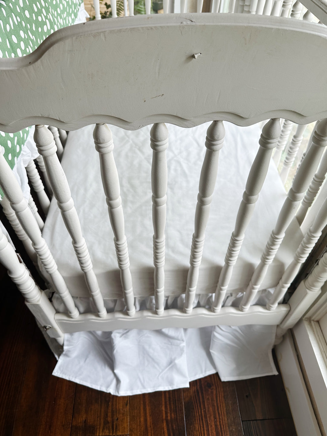 Foot of the crib with the white farmhouse skirt at a 20-inch drop