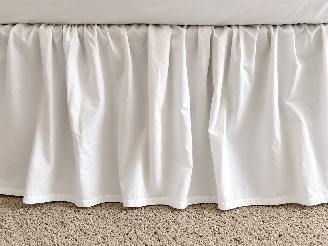 Full side view of the white farmhouse bed skirt showing even gathers along the length of the bed and a 20 inch drop to the floor