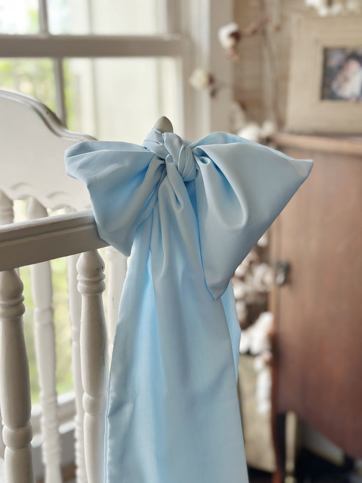 Soft-focus view of the tied blue bow with an antique armoire in the background