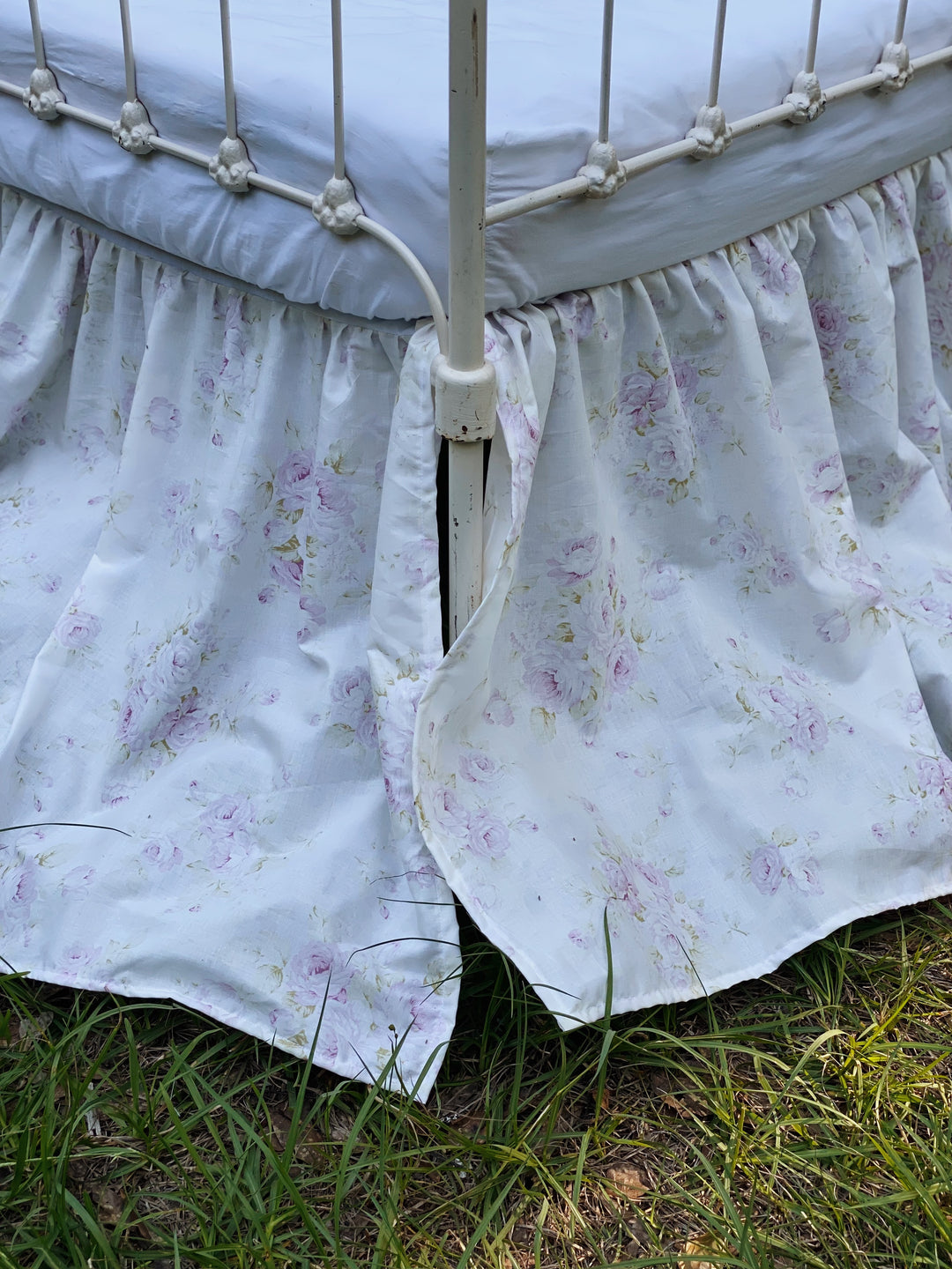 Close-up of gathered lavender rose print washed cotton crib skirt detail on angled view