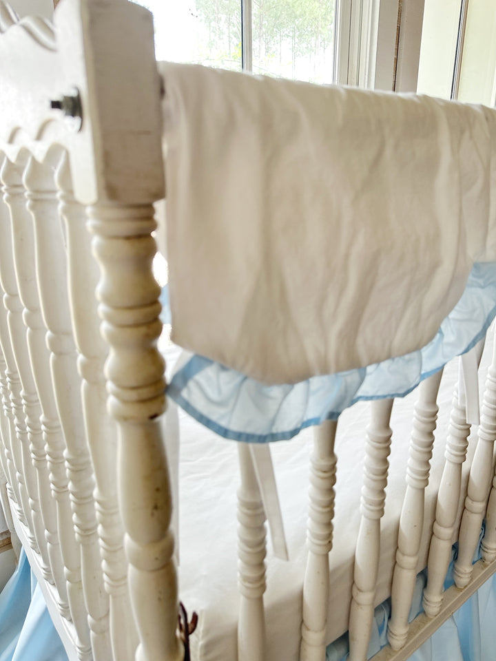 Angled view along the rail showing how the cover drapes and where the ties fall between spindles