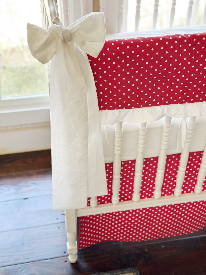 Large white bow knotted at the corner post against the red polka dot rail cover