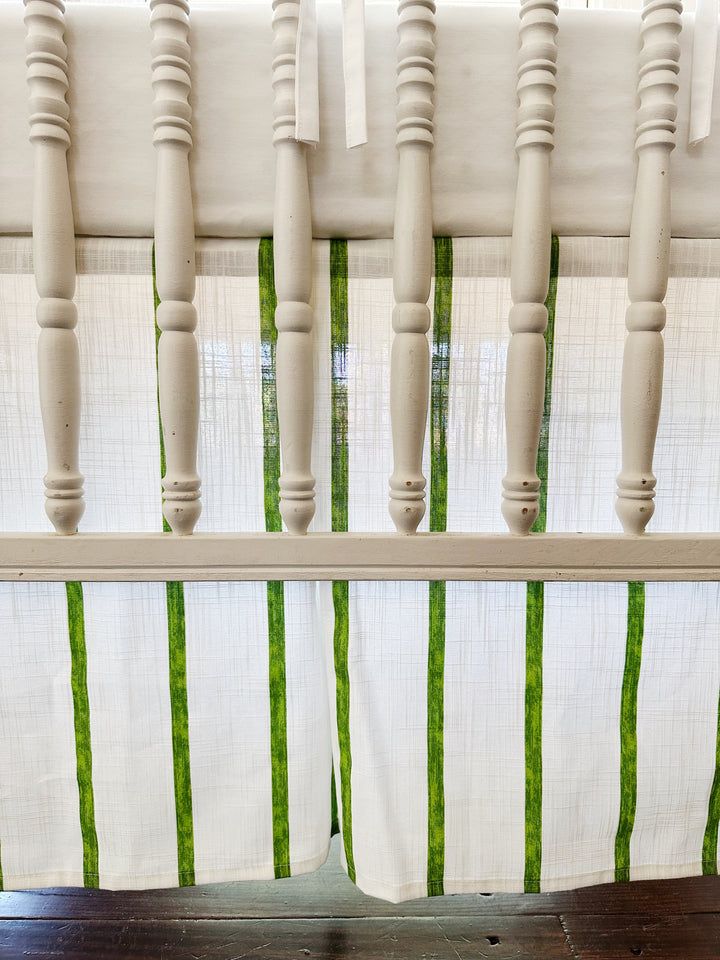 Detail of the tailored striped skirt and its center pleat seen between the crib spindles