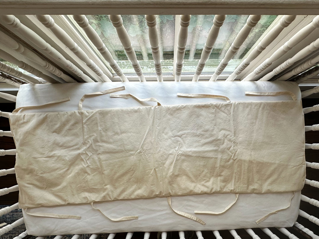 Long Natural crib rail cover shown flat with soft ties along the bottom edge