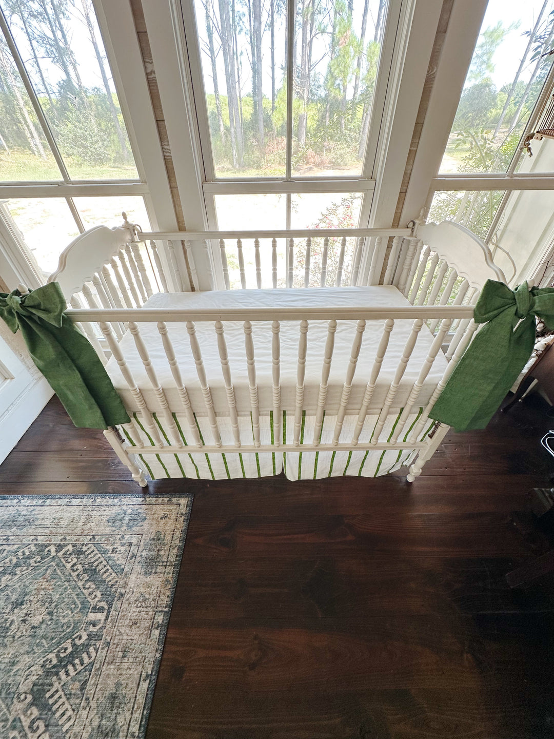 Overhead view of the crib with both green sashes and the striped tailored skirt