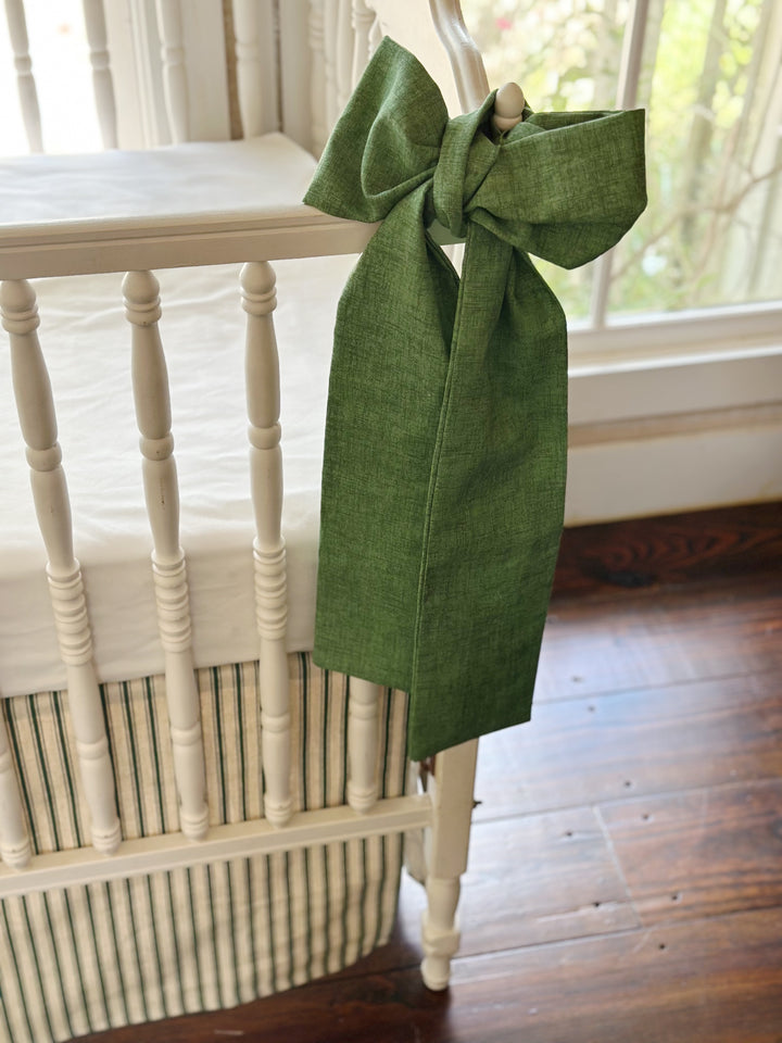 Tight crop of the green sash tails and the woven texture of the solid cypress green cotton