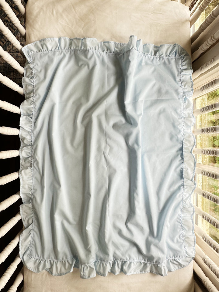 Heirloom blue ruffled crib blanket laid flat showing the hemmed cotton ruffle on all four sides - High Cotton Textile