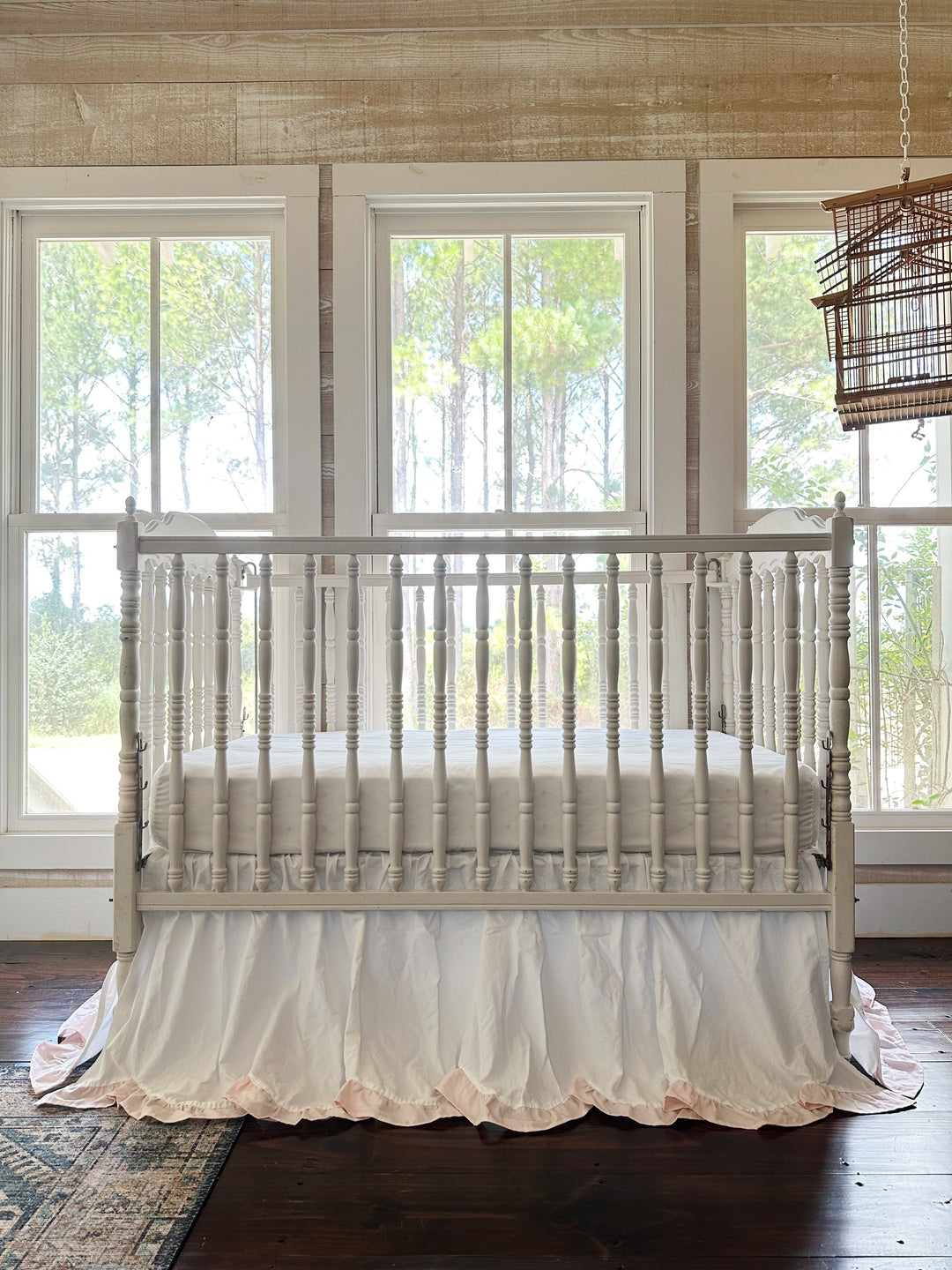 Full nursery view with the scalloped crib skirt centered beneath three windows