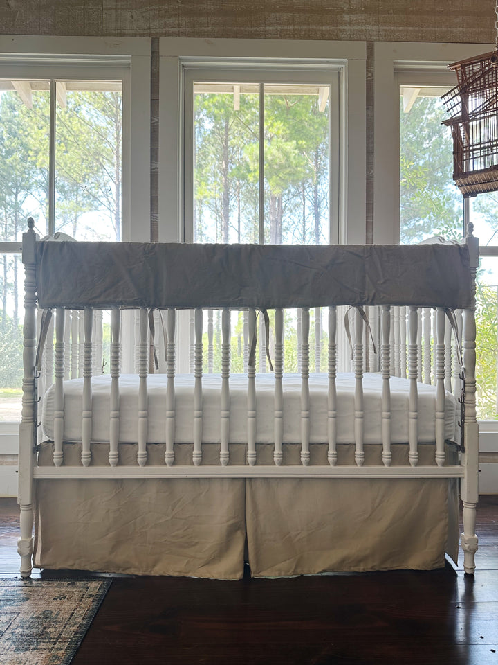 Oatmeal tailored crib skirt with pleated corners on white spindle crib - High Cotton Textile