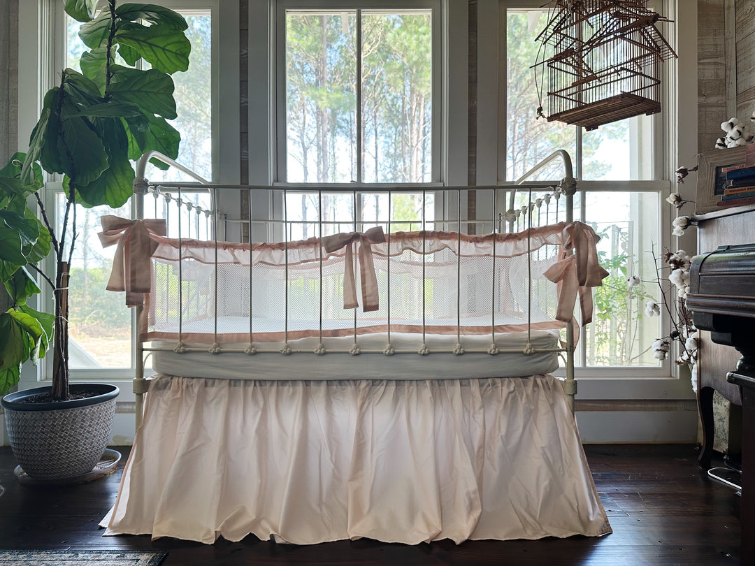 Full product set on crib, showing combination of ruffled mesh liners and gathered crib skirt in ballet slipper pink