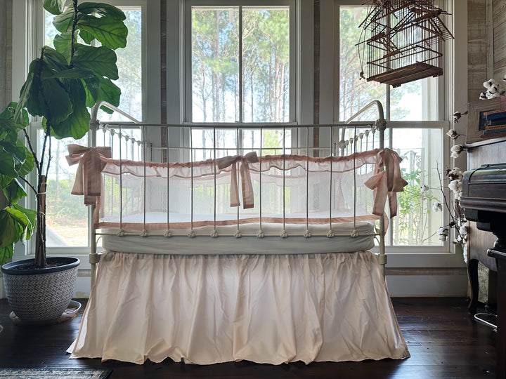 Full product set on crib, showing combination of ruffled mesh liners and gathered crib skirt in ballet slipper pink