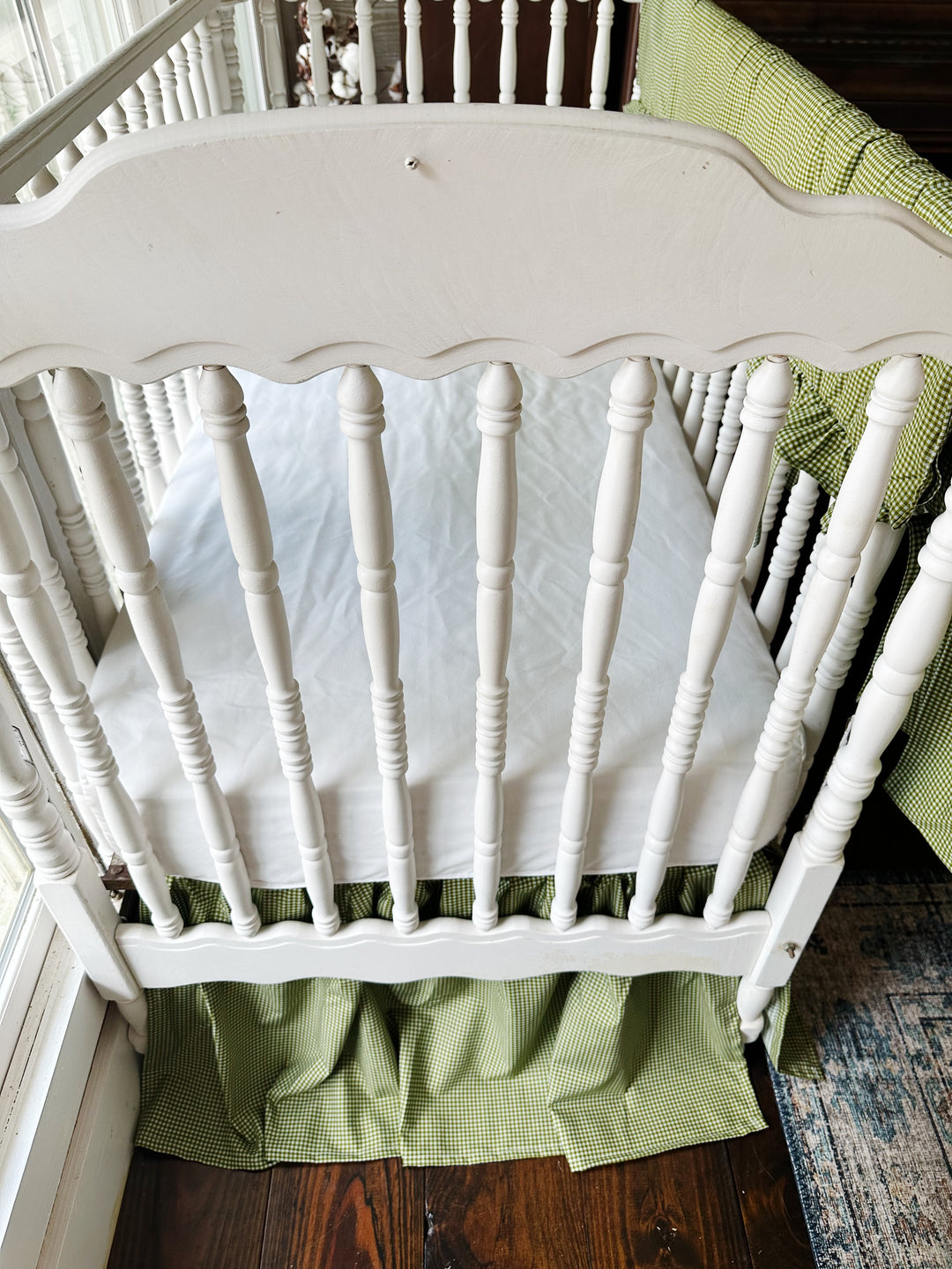 White fitted crib sheet paired with a pine green gingham farmhouse crib skirt