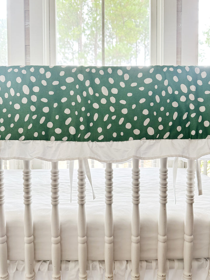 Close view of the irregular white spots on deep green cotton above the gathered white ruffle
