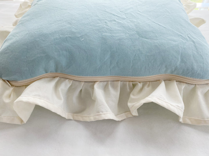 Detail of the hidden zip closure along the edge of the mist and ivory crib pillow