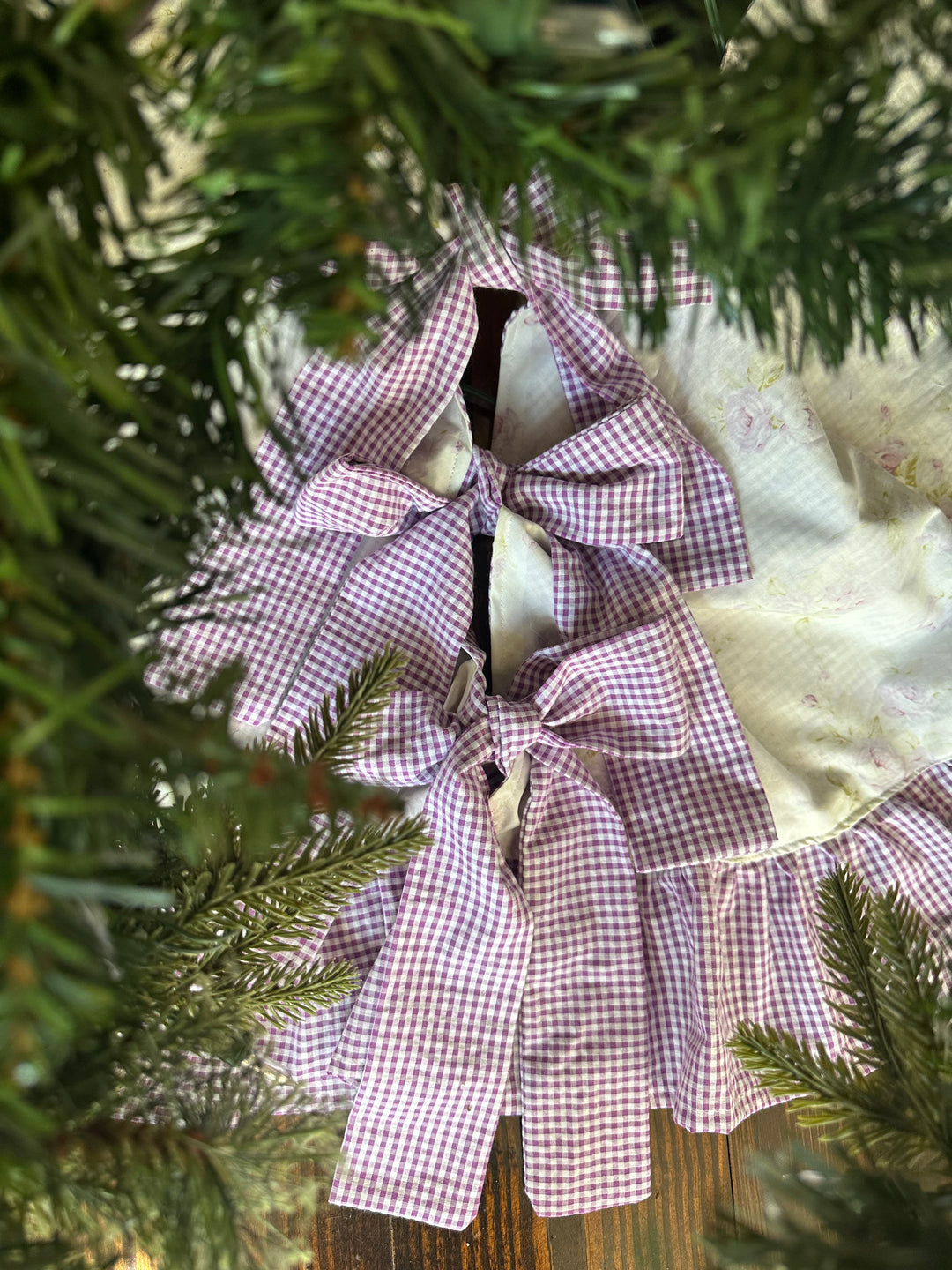 Looking down through pine branches at the lavender gingham bow ties closing the tree skirt