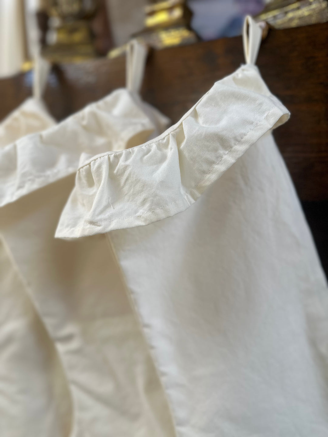 Close-up of the gathered ivory ruffle cuff and cotton hanging loop at the top of the stocking