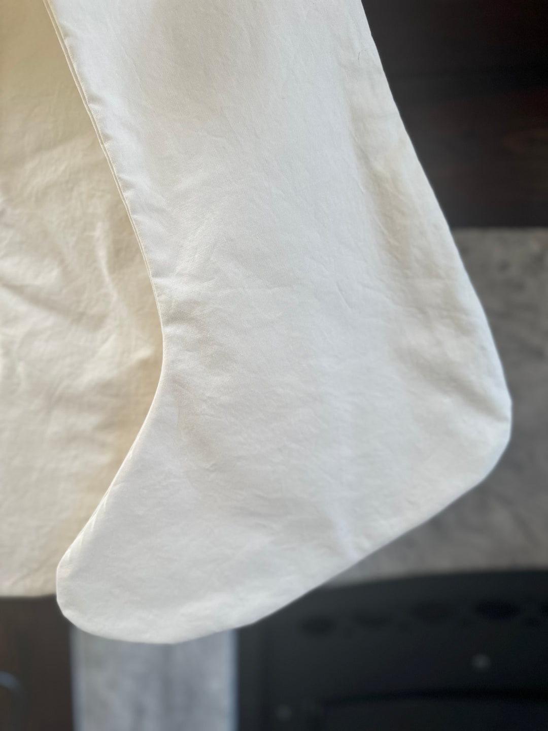 Detail of the curved toe and washed cotton texture on an ivory Christmas stocking