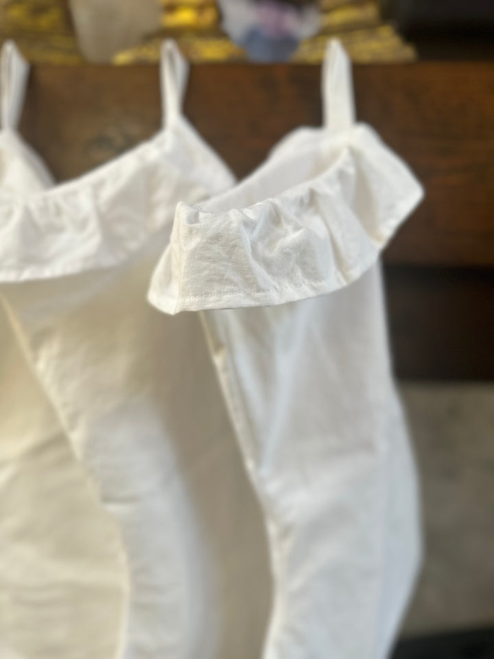 Soft close-up of the gathered white ruffle at the top of a cotton stocking