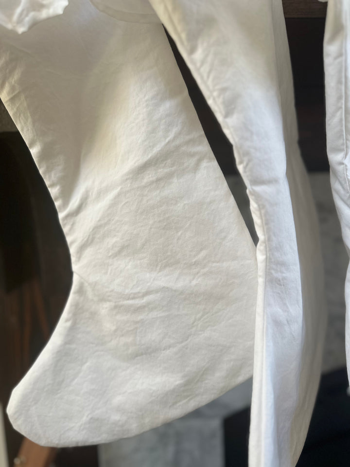Heel and toe of a white ruffled stocking up close, showing the soft washed cotton
