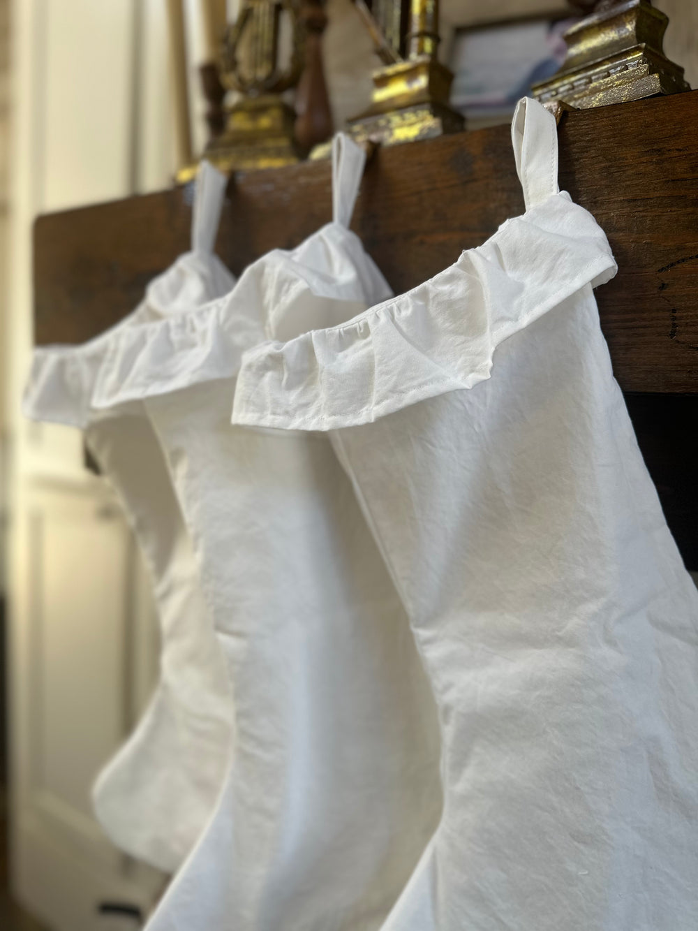 Angled view of the row of white cotton stockings, each ruffled cuff overlapping the next