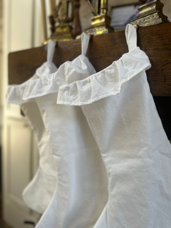 Angled view of the row of white cotton stockings, each ruffled cuff overlapping the next