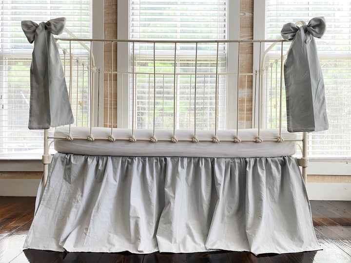 Close-up of large zen grey crib bow tied on white iron crib post, oversized farmhouse nursery bow detail
