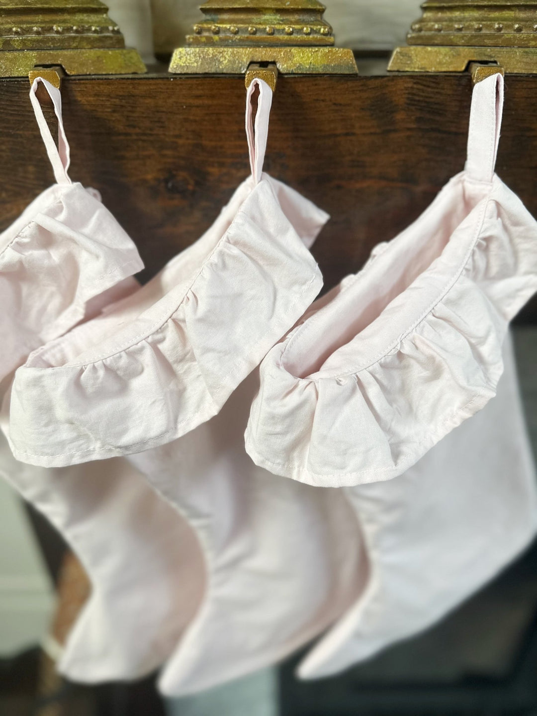 Looking down into the ruffled cuffs of baby pink cotton stockings on the mantel