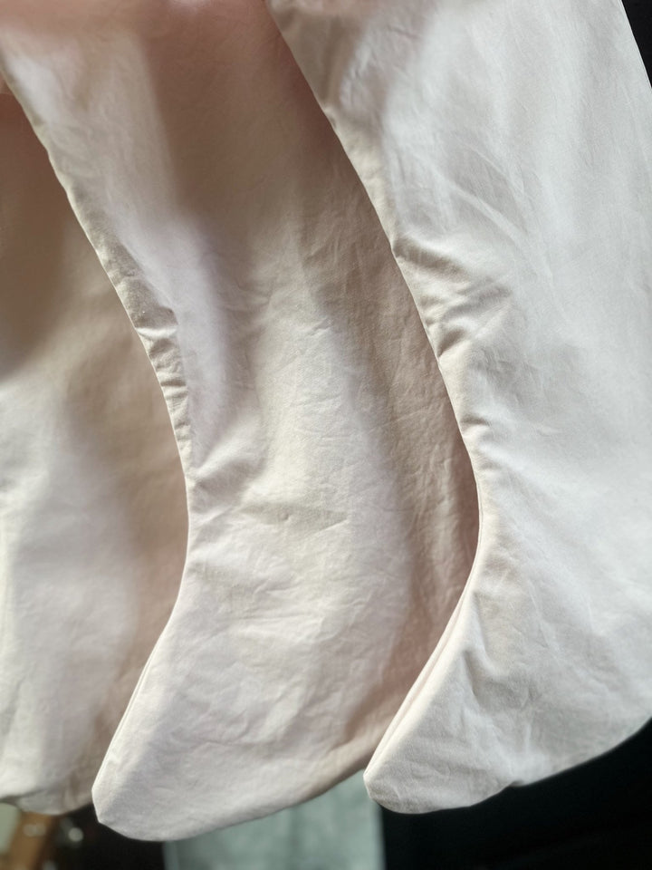 Close-up of the soft baby pink washed cotton fabric of two Christmas stockings