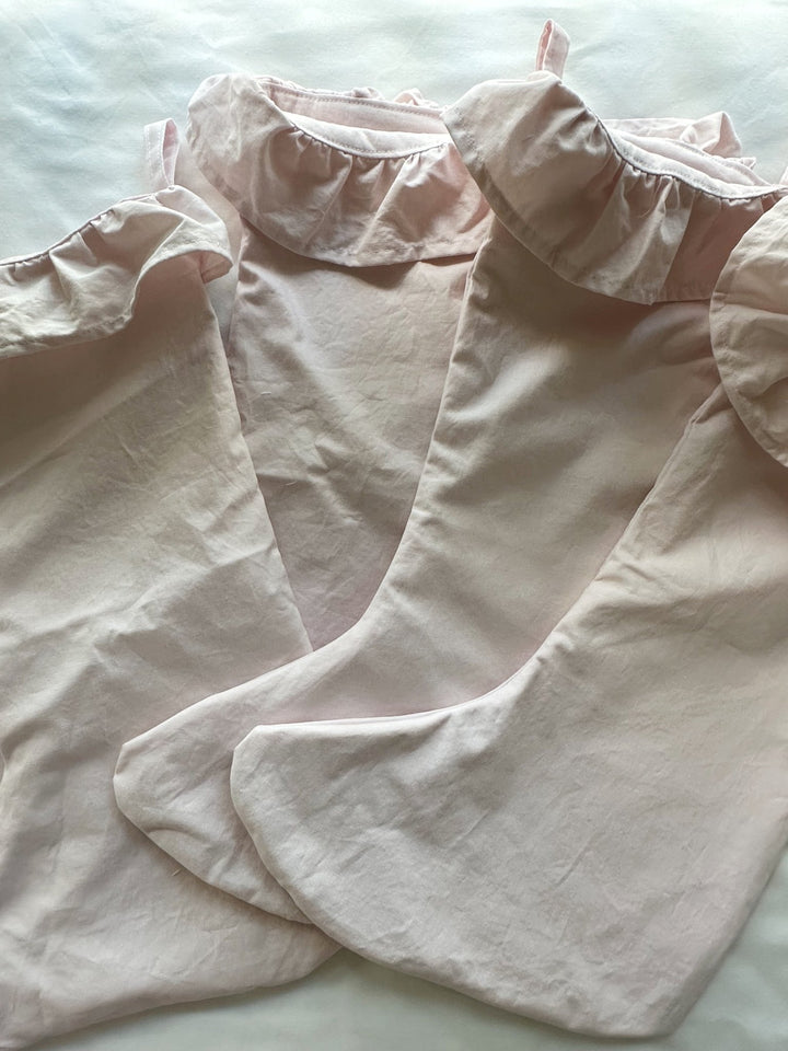 Detail of the gathered baby pink ruffle and toe of the cotton Christmas stockings