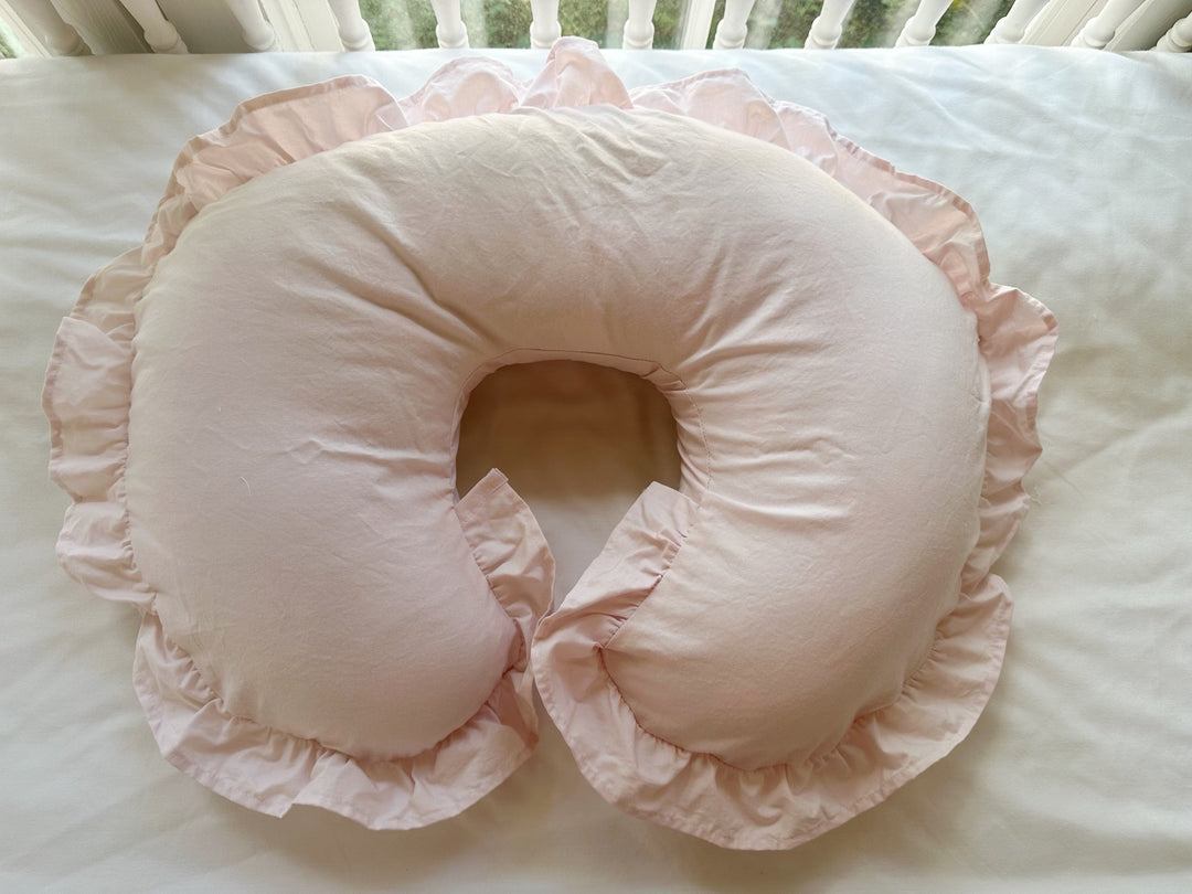 Front view of the Baby Pink nursing pillow cover with its gathered ruffle flouncing around both tips