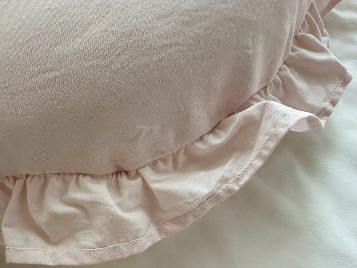 Close-up of the hand-gathered Baby Pink ruffle with a narrow stitched hem along the pillow edge